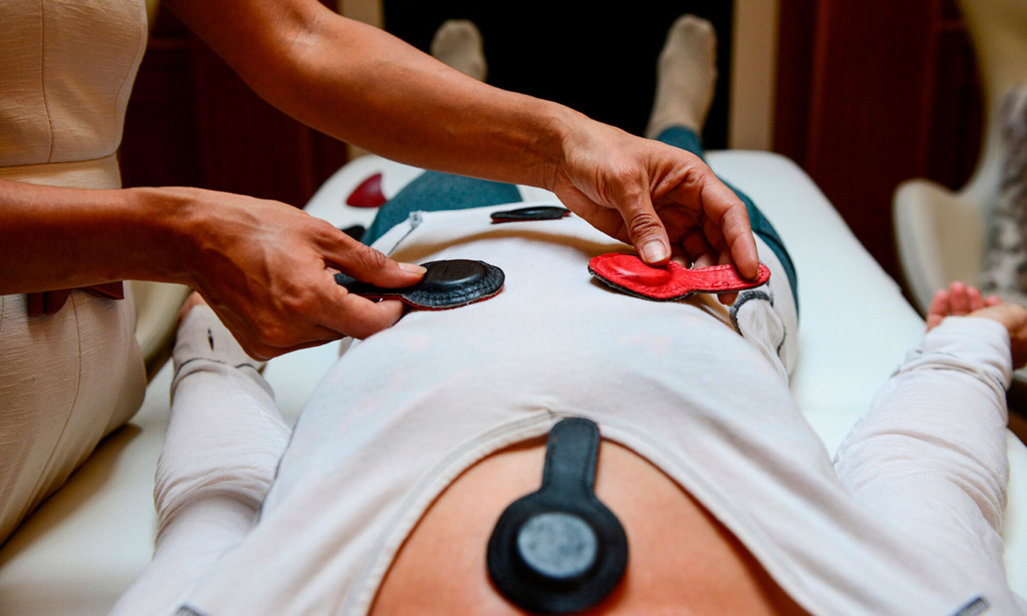 Mujer acostada tomando sesion de terapia con imanes. Curo con Imanes Esperanza Lavín. Terapia con Imanes. Terapia de Imanes.